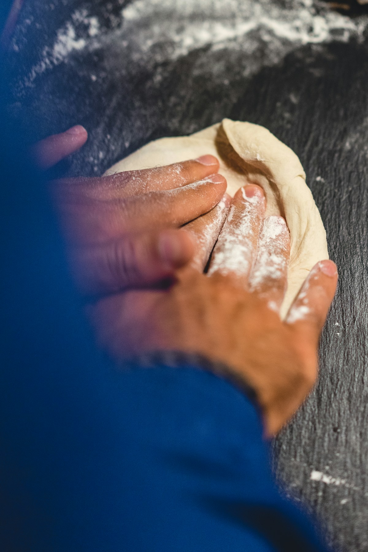 Illustrative hands shaping pizza dough